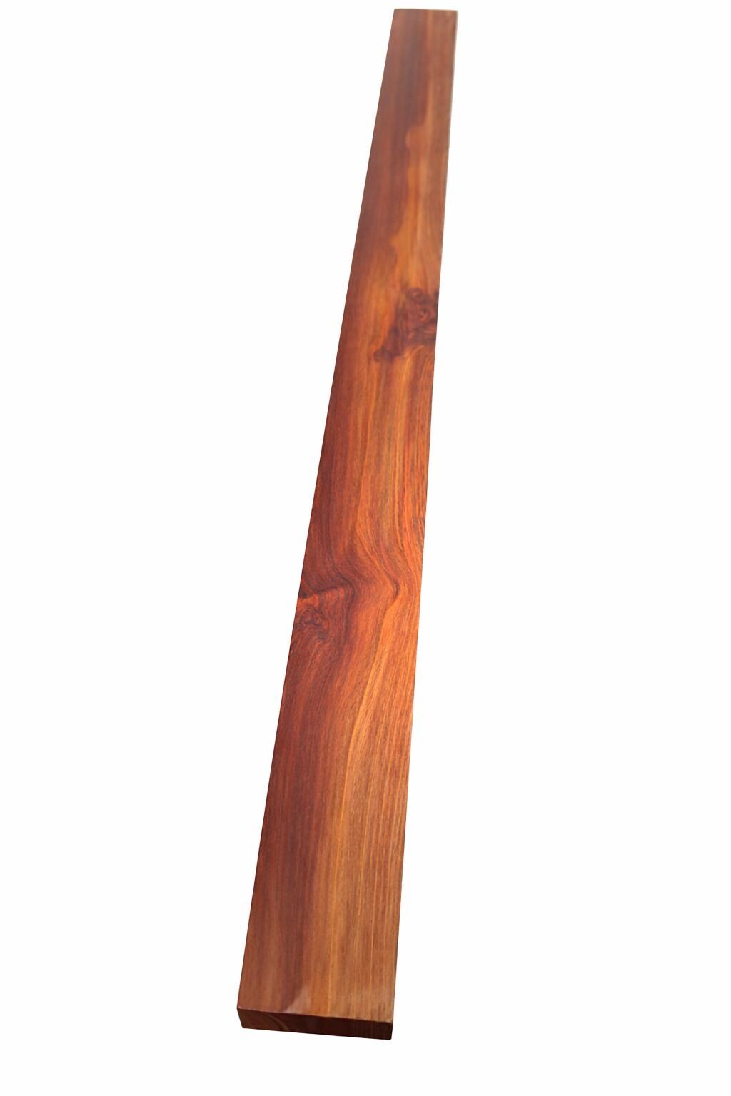 Red-brown exotic hardwood board with golden chatoyance and dense grain